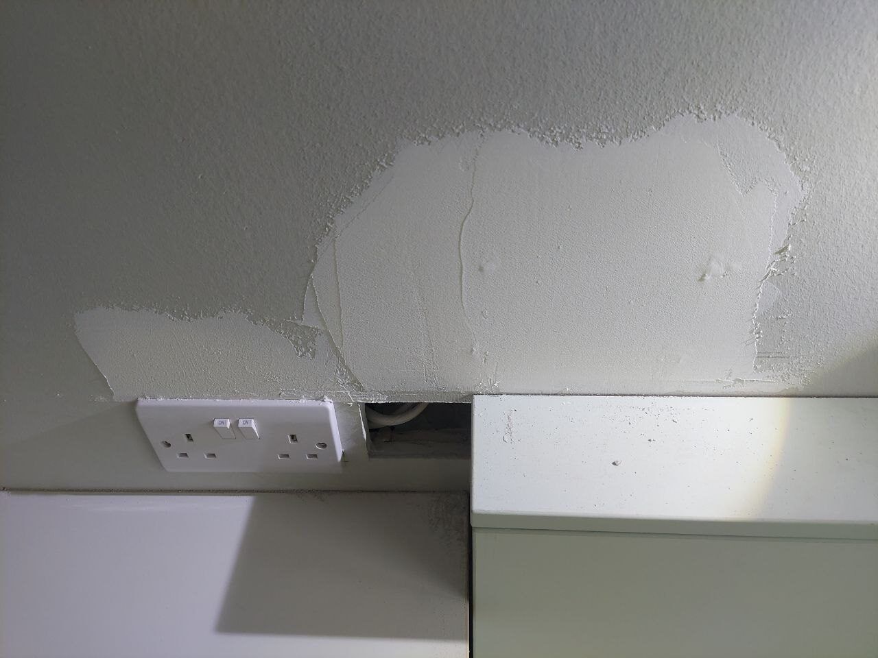 Torn plaster beside a socket